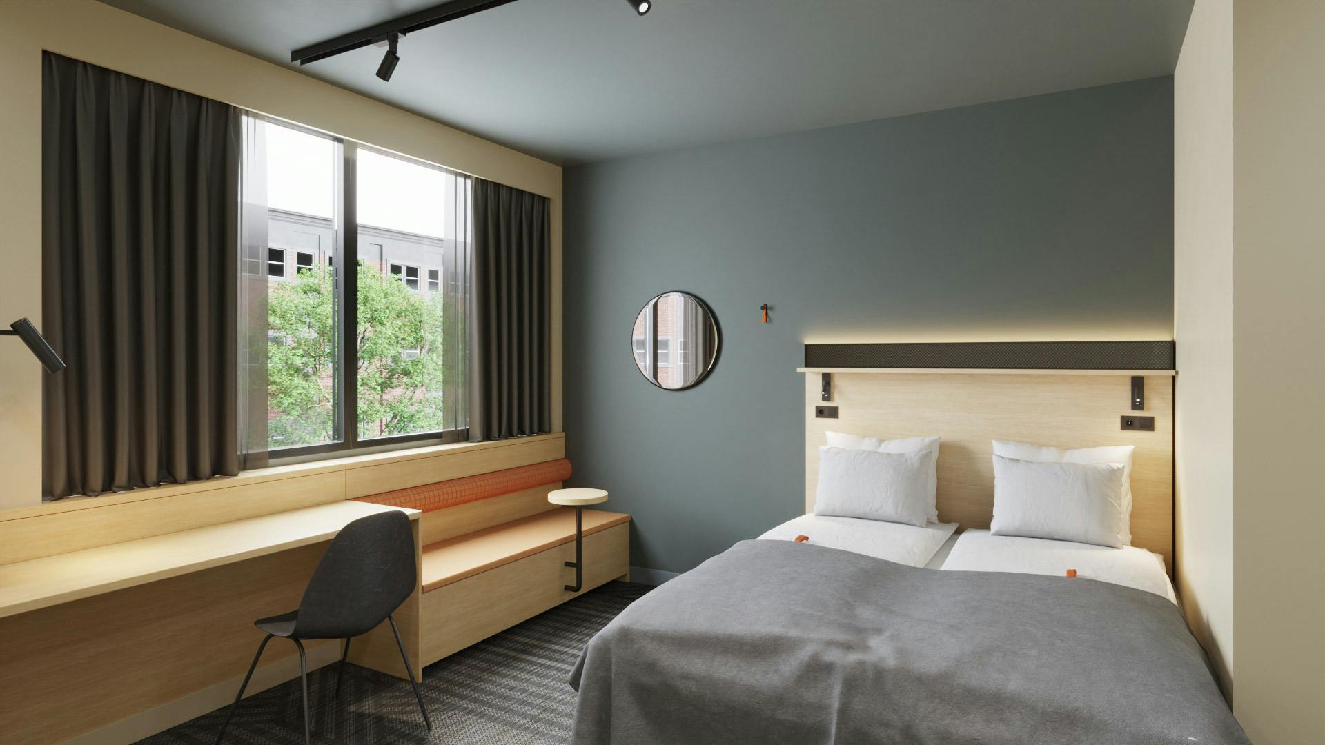Small double room in Citybox Brussels. Bed, desk, seating area and windows.